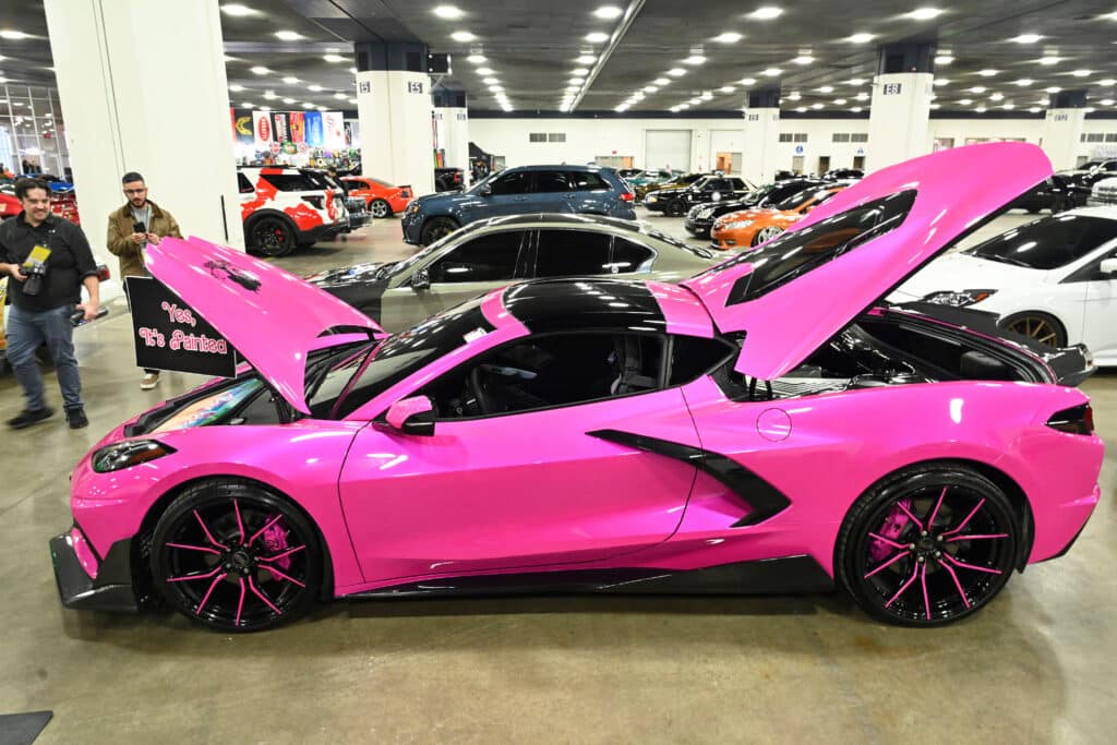 Bright pink sports car with open hoods.