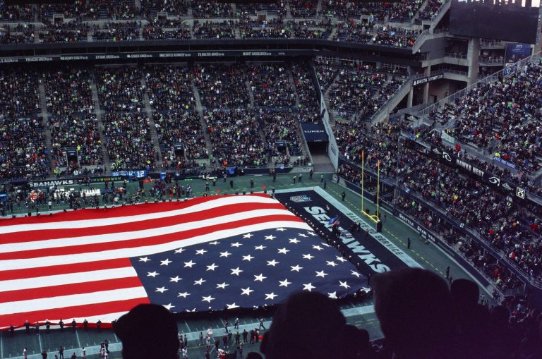 Super Bowl 2026 Patriots boring a large american flag is displayed in a stadium