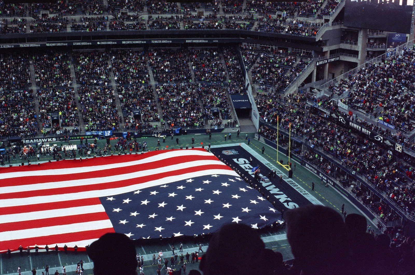 Super Bowl 2026 Patriots boring a large american flag is displayed in a stadium